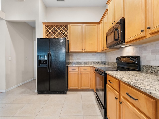 kitchen with light stone counters, decorative backsplash, black appliances, and light tile patterned flooring