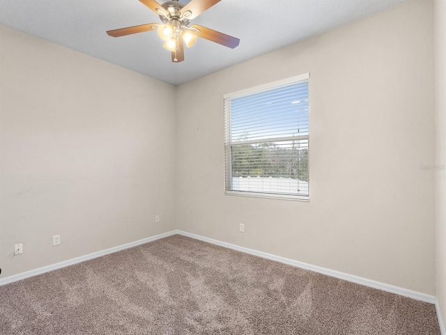 unfurnished room with ceiling fan and carpet