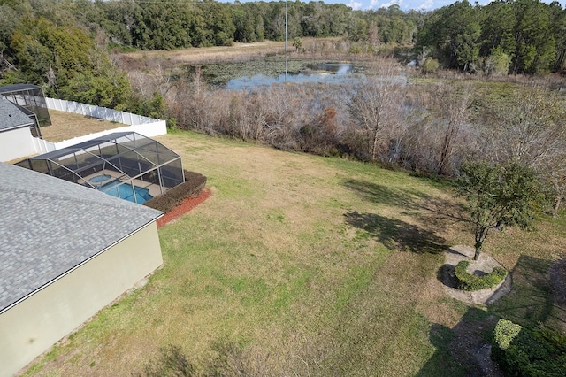 view of yard featuring a water view and glass enclosure