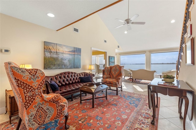 living room with high vaulted ceiling, light tile patterned flooring, ceiling fan, and a water view