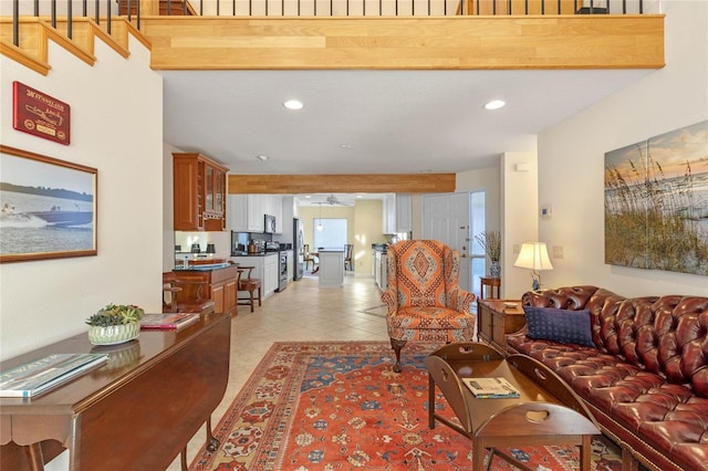 living room with beamed ceiling, light tile patterned floors, and ceiling fan