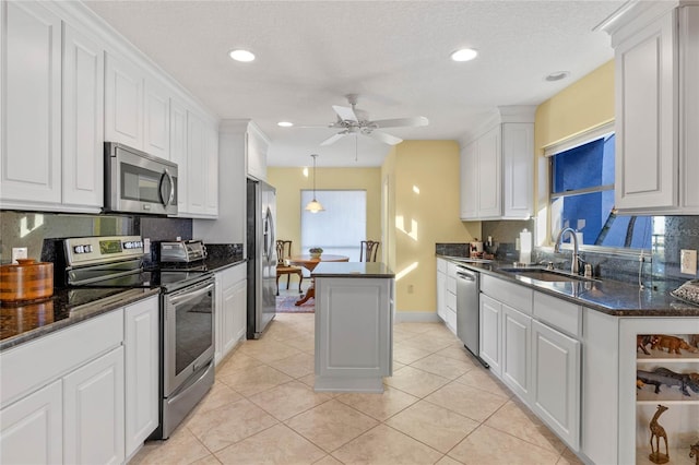 kitchen with white cabinetry, stainless steel appliances, a center island, and sink