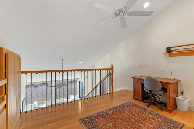 home office with vaulted ceiling, light hardwood / wood-style floors, and ceiling fan