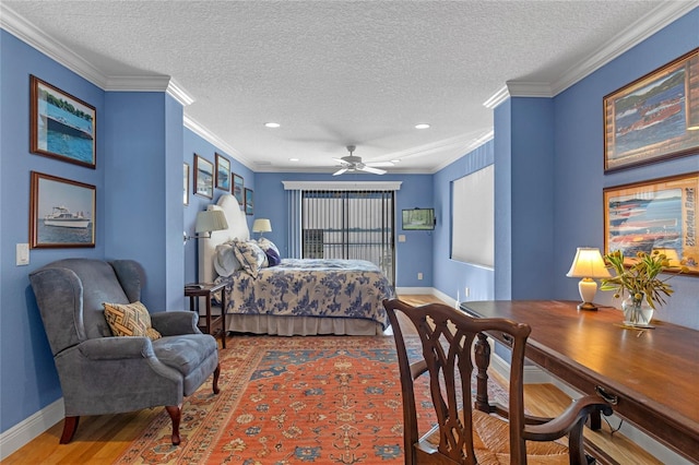 bedroom featuring ceiling fan, ornamental molding, hardwood / wood-style floors, and a textured ceiling