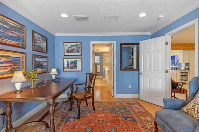 office area featuring crown molding, a textured ceiling, and light wood-type flooring