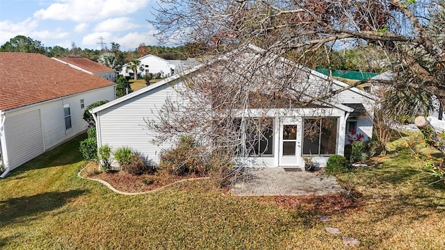 back of house featuring a patio area and a lawn