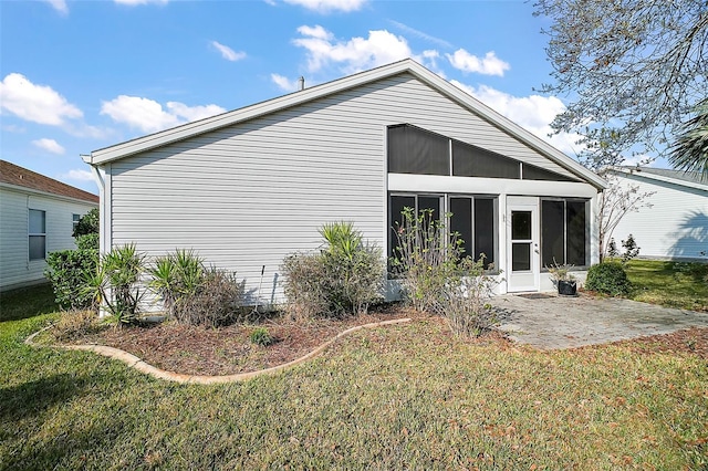 back of property featuring a sunroom, a yard, and a patio area