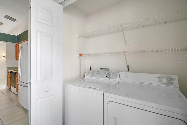 washroom with light tile patterned floors and independent washer and dryer