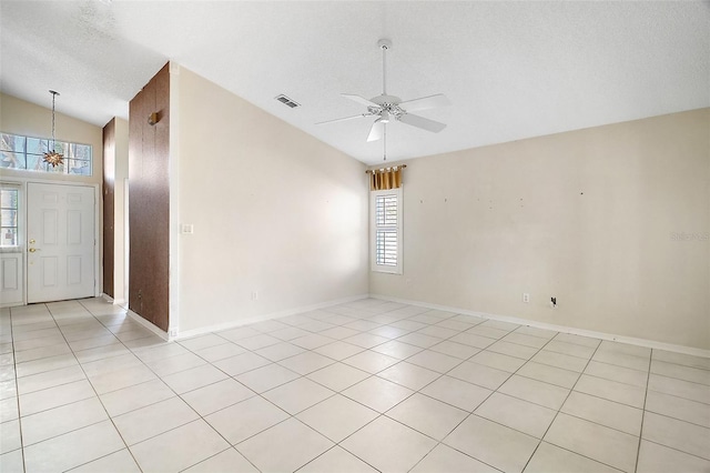 tiled empty room featuring vaulted ceiling, a textured ceiling, and ceiling fan