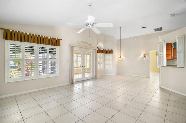 tiled spare room featuring lofted ceiling, ceiling fan, and french doors