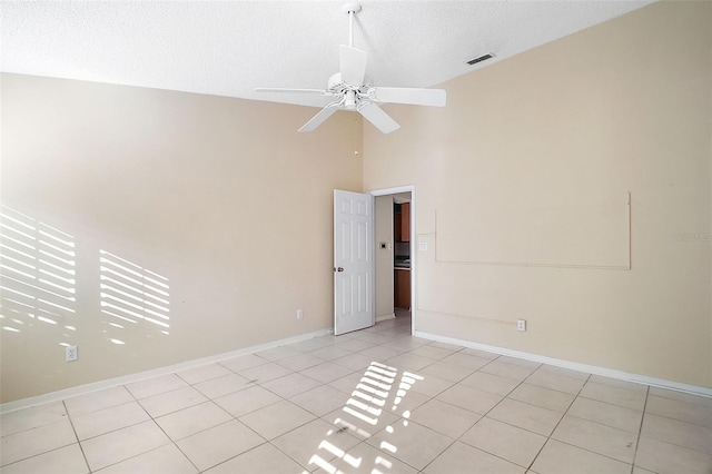 tiled spare room featuring ceiling fan, high vaulted ceiling, and a textured ceiling