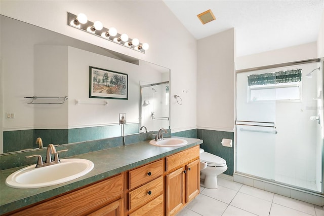 bathroom featuring tile patterned floors, toilet, an enclosed shower, tile walls, and vanity