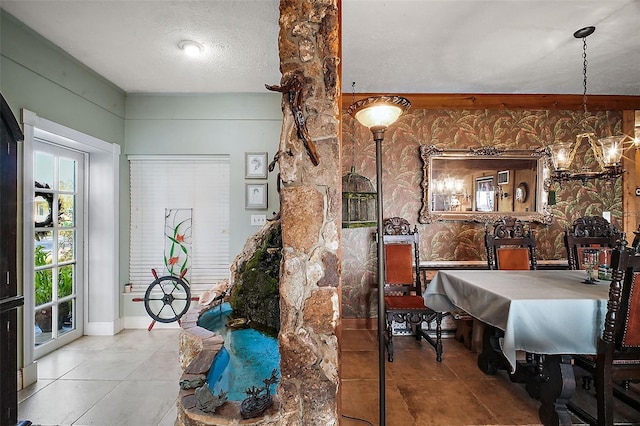 dining space with tile patterned flooring, a chandelier, and a textured ceiling