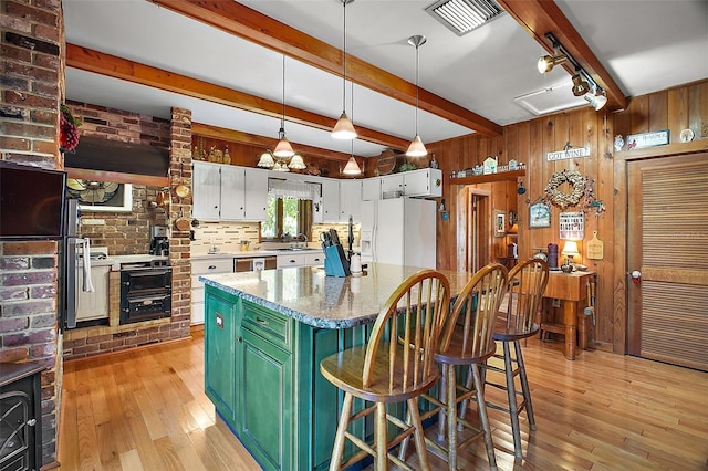 kitchen with white cabinets, wooden walls, green cabinetry, and white fridge with ice dispenser