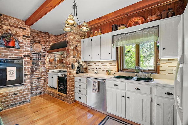 kitchen with pendant lighting, black oven, white cabinetry, sink, and stainless steel dishwasher