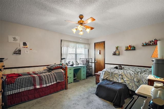 bedroom featuring ceiling fan, carpet floors, and a textured ceiling