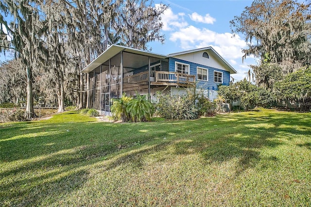 rear view of house with a yard and a sunroom