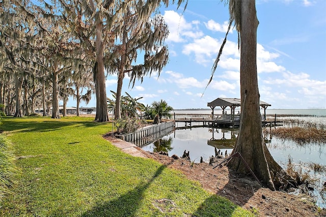 view of dock featuring a water view and a lawn