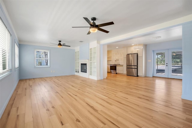 unfurnished living room featuring french doors and light hardwood / wood-style flooring