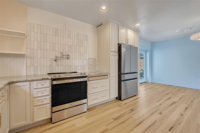 kitchen with light stone countertops, appliances with stainless steel finishes, white cabinets, and decorative backsplash