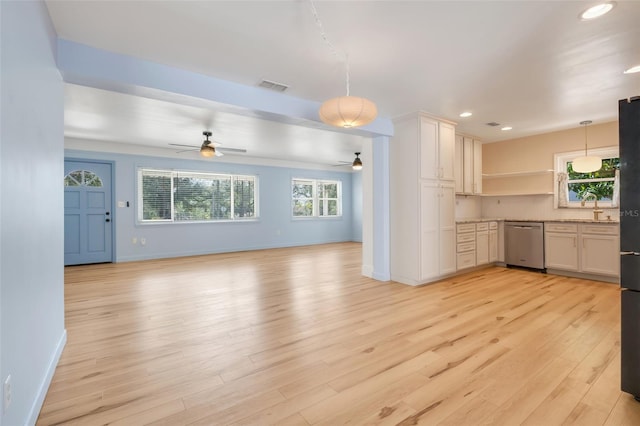 kitchen featuring sink, dishwasher, hanging light fixtures, white cabinets, and light wood-type flooring