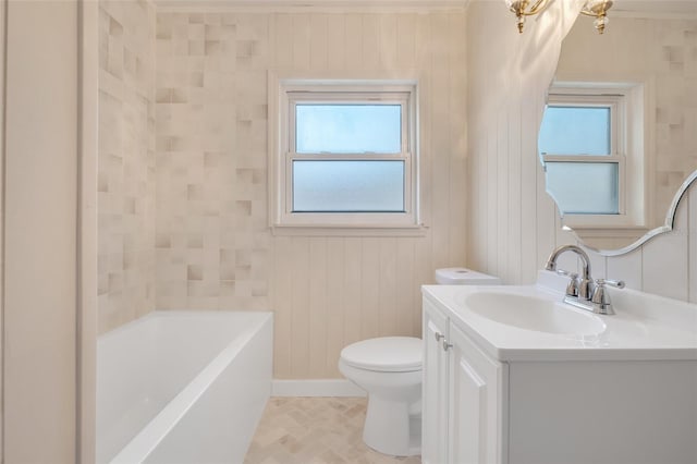 bathroom featuring a tub, vanity, toilet, and a wealth of natural light