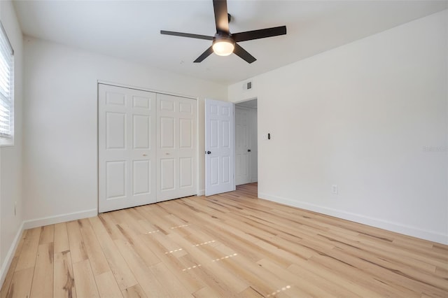 unfurnished bedroom with light hardwood / wood-style flooring, a closet, and ceiling fan