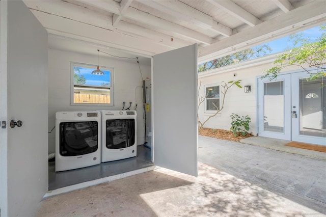 washroom with water heater, washer and dryer, and french doors