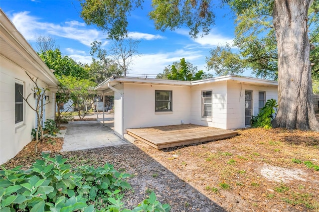 back of property with a wooden deck and a patio area