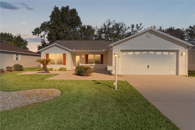 ranch-style house with a garage, a yard, and covered porch