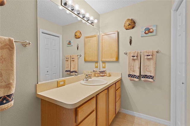 bathroom with vanity, tile patterned floors, and a textured ceiling