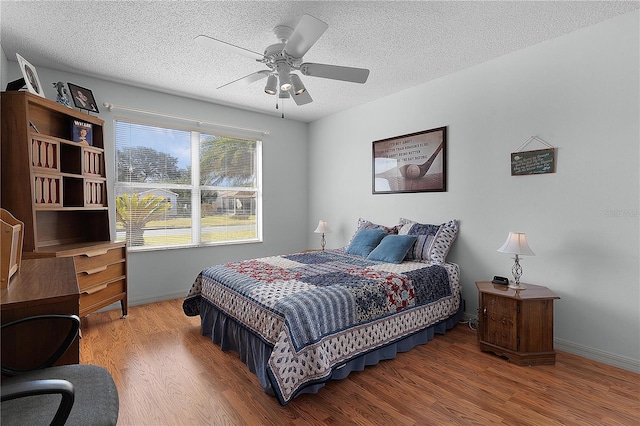 bedroom with wood-type flooring, ceiling fan, and a textured ceiling