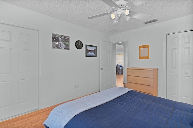 bedroom featuring ceiling fan, hardwood / wood-style flooring, a closet, and a textured ceiling