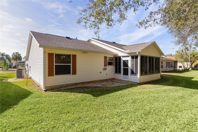 back of property with a yard, central AC unit, and a sunroom