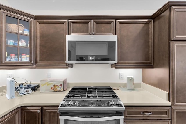 kitchen featuring dark brown cabinets and appliances with stainless steel finishes