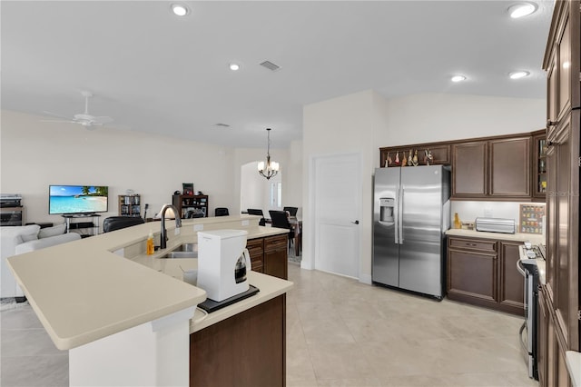 kitchen with ceiling fan with notable chandelier, sink, dark brown cabinetry, stainless steel appliances, and a center island with sink