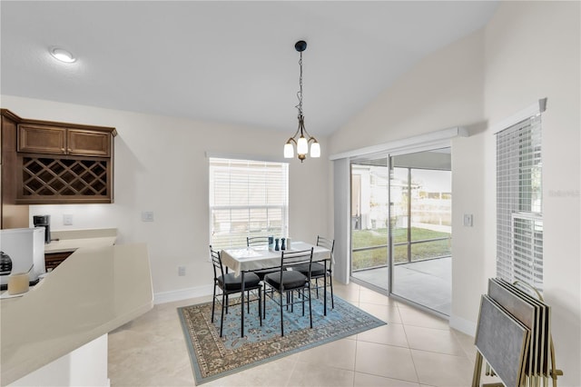 dining area featuring a notable chandelier, vaulted ceiling, light tile patterned flooring, and plenty of natural light