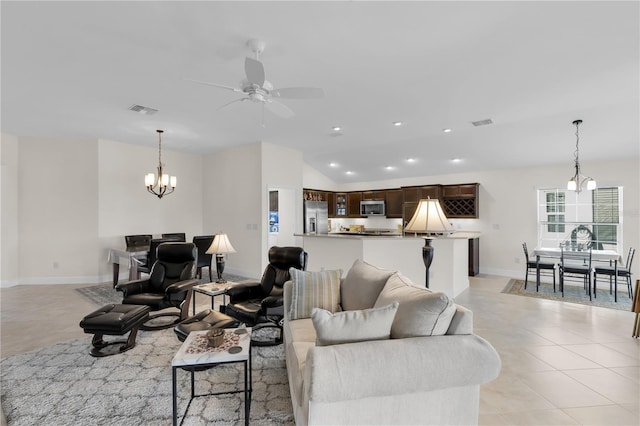 tiled living room with ceiling fan with notable chandelier and vaulted ceiling