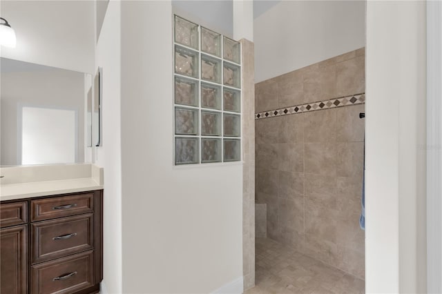 bathroom with vanity and tiled shower