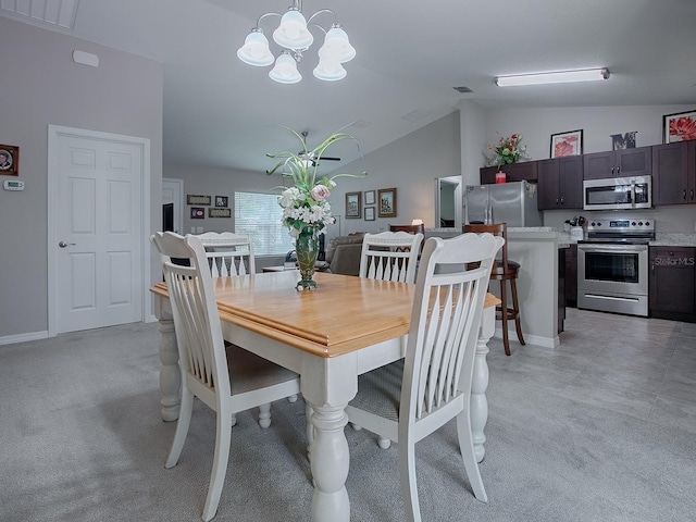 dining space featuring an inviting chandelier, light colored carpet, and lofted ceiling