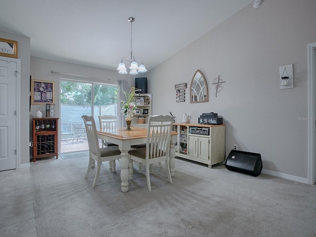 dining space featuring lofted ceiling, light colored carpet, and a chandelier