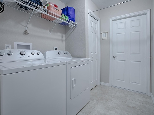 washroom featuring separate washer and dryer and light tile patterned floors