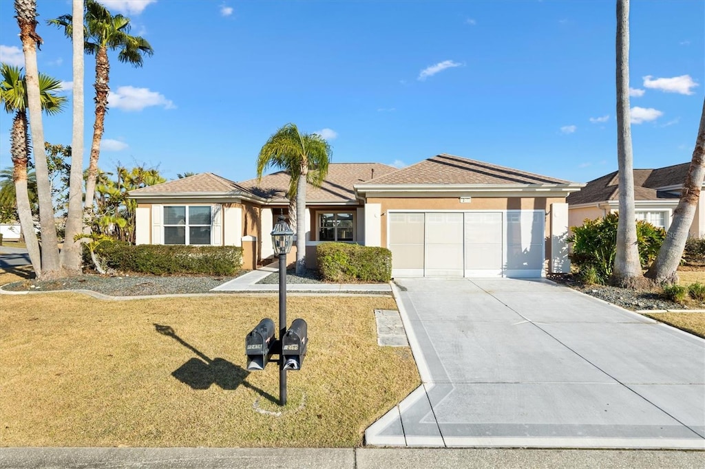 ranch-style house featuring a garage and a front lawn