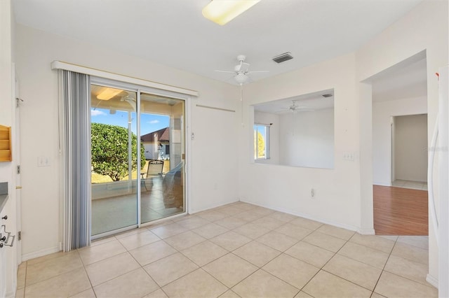 tiled spare room with plenty of natural light and ceiling fan