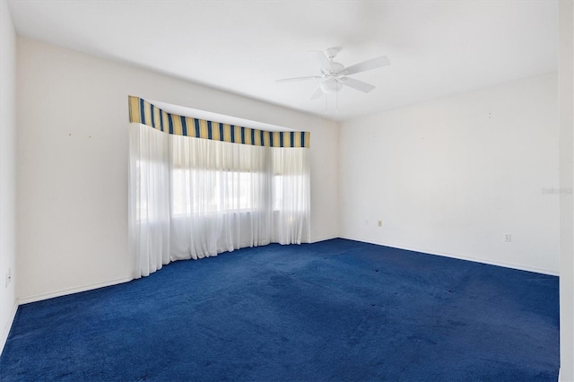 empty room with dark carpet and ceiling fan
