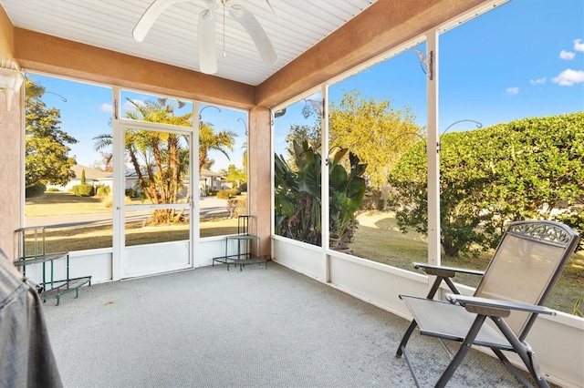unfurnished sunroom featuring ceiling fan and a wealth of natural light