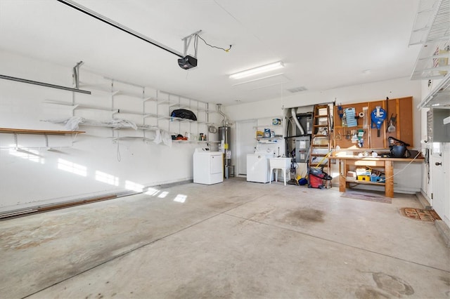 garage featuring sink, a garage door opener, a workshop area, washing machine and dryer, and gas water heater