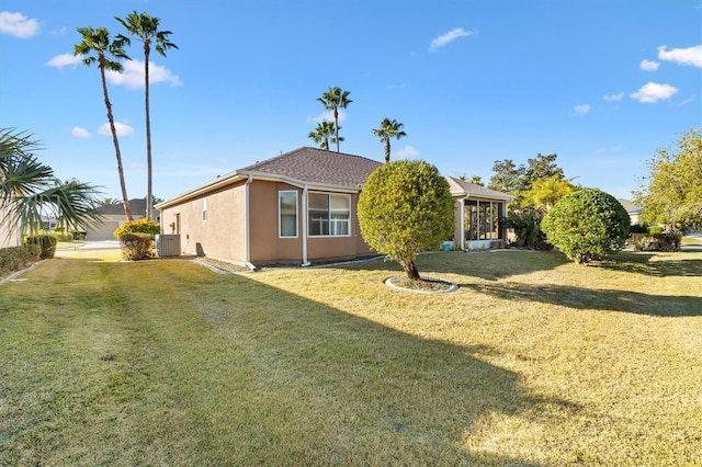 exterior space with central AC and a lawn