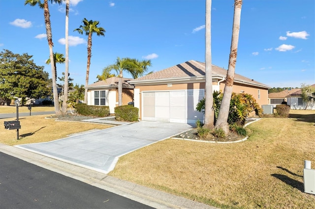 single story home with central AC, a garage, and a front yard
