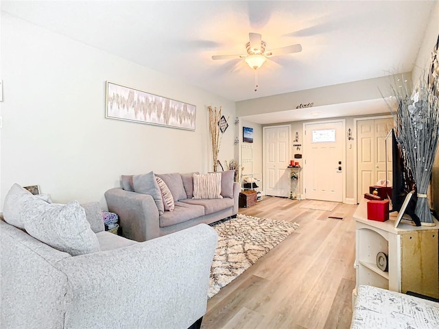 living room featuring wood-type flooring and ceiling fan